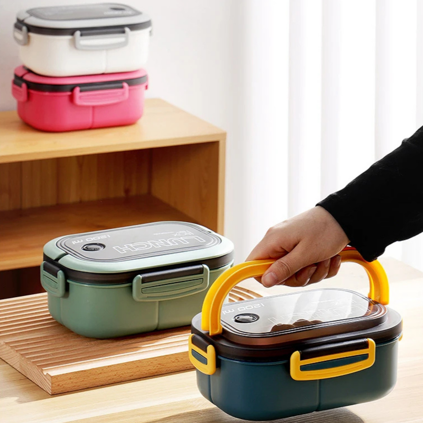 Person holding blue lunch box by handles with other lunchboxes in background