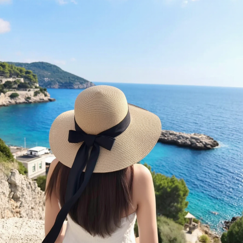 Light coffee sun hat worn by woman near the sea – foldable and stylish for Mediterranean holidays