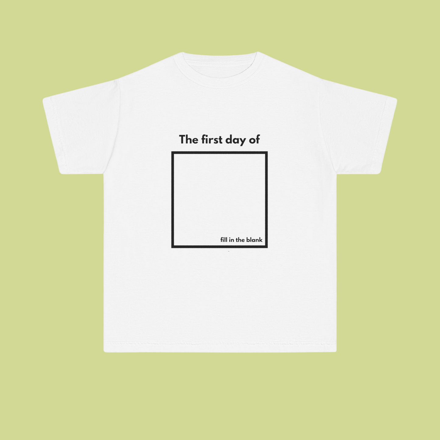 White t-shirt with text 'The first day of fill in the blank' on a light green background