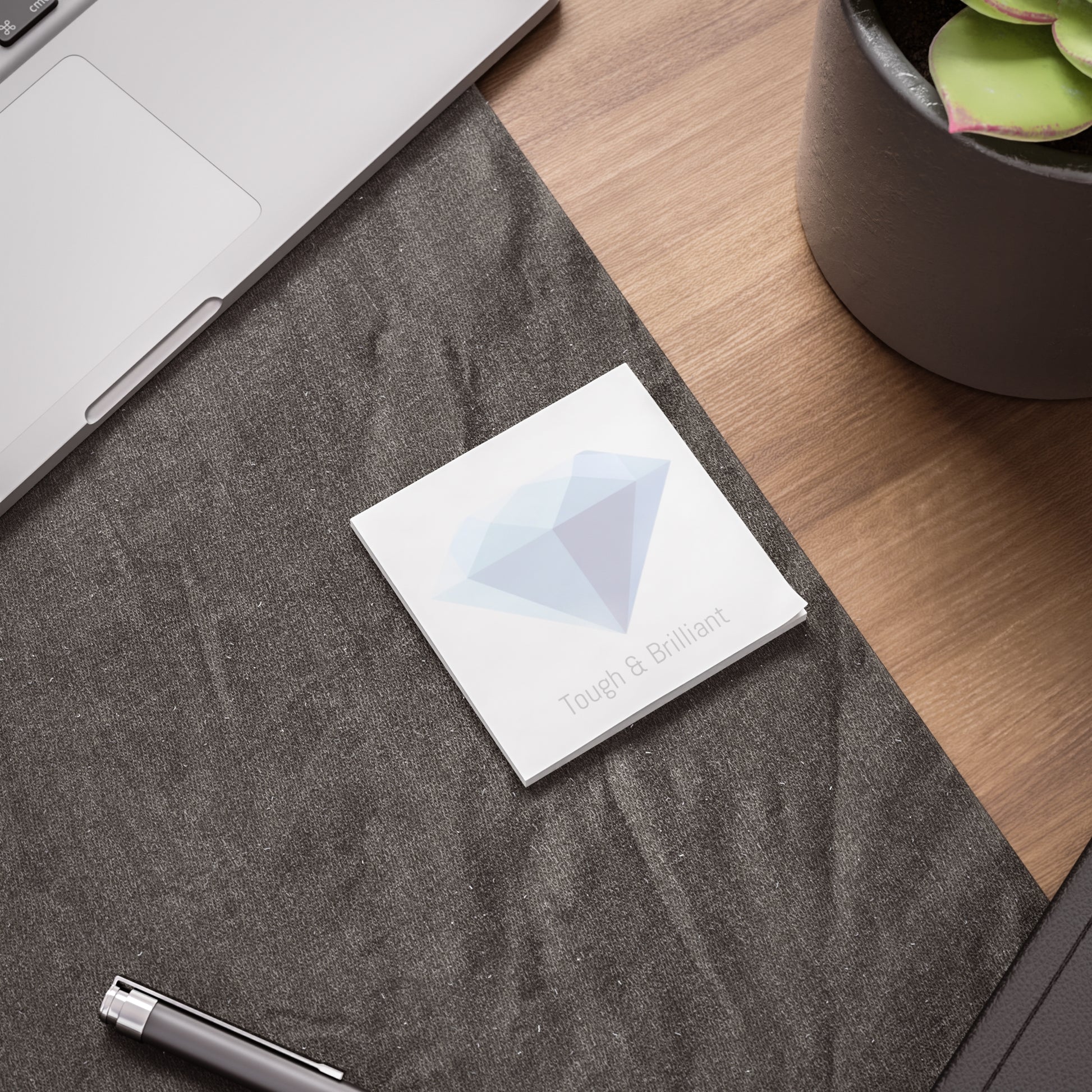 Diamond gem Post-it pad on desk beside laptop and pen