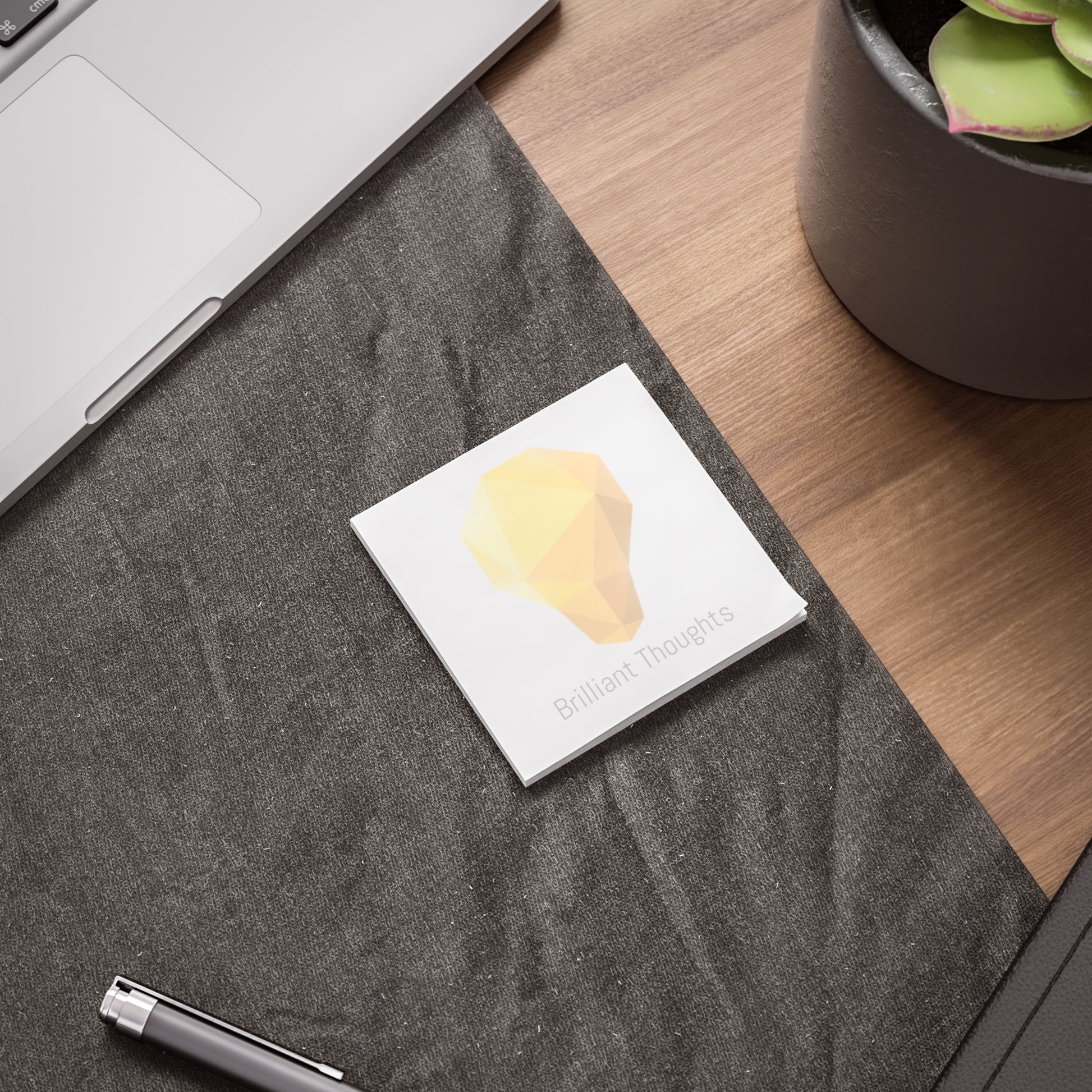Lightbulb gem Post-it pad on desk beside laptop and pen